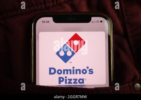 KONSKIE, POLEN - 17. August 2021: Dominos Pizza-Logo auf dem Mobiltelefon, versteckt in der Jeans-Tasche Stockfoto