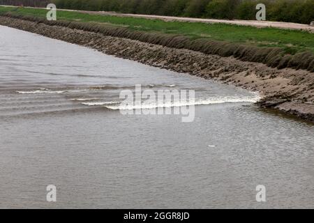 Brechende Wellen an den Kanalseiten der tne Dee Tidal Bore im New Cut Kanal zwischen Queensferry und Saltney Ferry Stockfoto