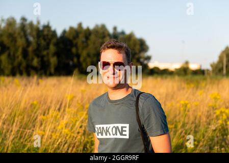 Gent, Region Ostflandern, Belgien - 07 18 2021: Porträt eines attraktiven, sportlichen 40-jährigen Mannes mit Sonnenbrille und natürlichem Hintergrund Stockfoto