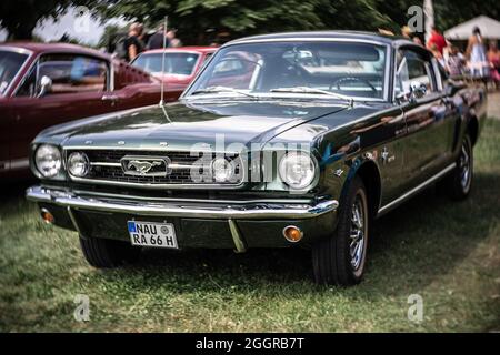 Der legendäre Sportwagen Ford Mustang Fastback Coupé. Fokus auf Zentrum. Wirbeliges Bokeh. Die Ausstellung von 'US Car Classics'. Stockfoto