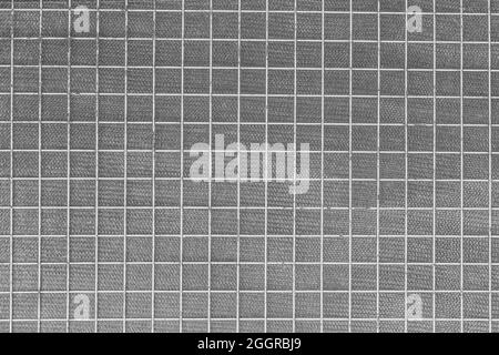 Weißer quadratischer Metalldraht aus Eisen auf grauem Netzhintergrund. Stockfoto