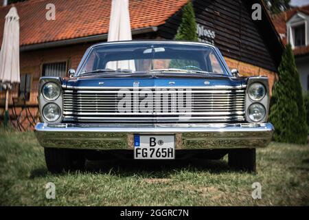 Der Vollformatwagen Ford Galaxie 500 LTD, 1965. Fokus auf Zentrum. Wirbeliges Bokeh. Die Ausstellung von 'US Car Classics'. Stockfoto