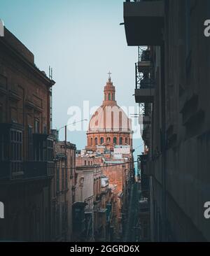 VALLETTA, MALTA - 09. Aug 2021: Eine vertikale Aufnahme der St. Paul's Cathedral bei Sonnenuntergang vom Hügel der Mint Street aus gesehen Stockfoto