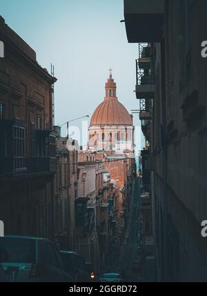 VALLETTA, MALTA - 09. Aug 2021: Eine vertikale Aufnahme der St. Paul's Cathedral bei Sonnenuntergang vom Hügel der Mint Street aus gesehen Stockfoto