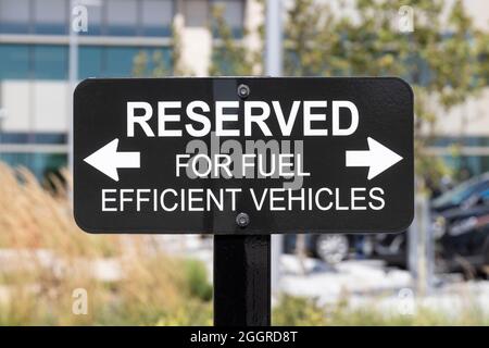 RESERVIERT für Fahrzeuge mit Kraftstoffeffizienz. Parkplätze sind für Elektro-, Elektro- und Hybrid-Elektrofahrzeuge reserviert, um die Umwelt und Sauberkeit zu fördern Stockfoto