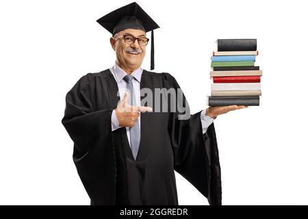 Reifer Mann in einem Abschlusskleid hält einen Stapel von Büchern und zeigt isoliert auf weißem Hintergrund Stockfoto