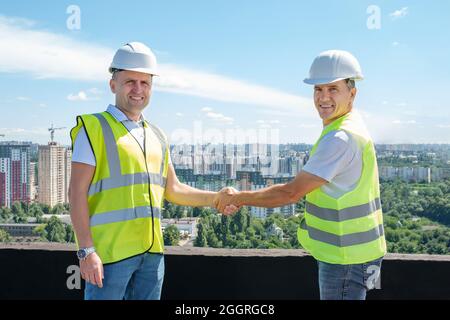 Architekt und Bauingenieur schütteln sich die Hände auf der Baustelle. Stockfoto