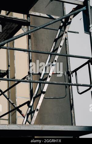 Vertikale Aufnahme einer Außentreppe neben einer Gebäudewand Stockfoto