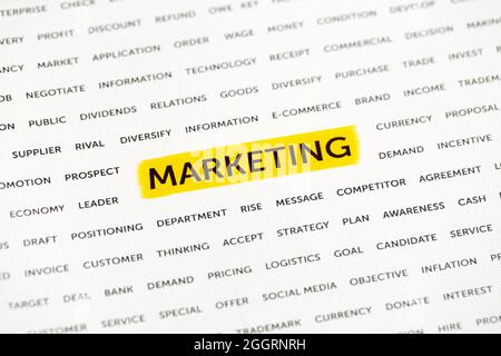 Das Wort „Marketing“ wird mit einer Markierung auf dem Papier hervorgehoben. Geschäftskonzept, Strategie, Planung, Erfolg Stockfoto