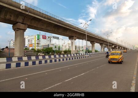 Gelbes Taxi mit frühmorgendlichem Verkehr auf der Stadtstraße mit Blick auf Überflüge und Geschäftsgebäude im Rajarhat-Gebiet Kalkutta, Indien Stockfoto