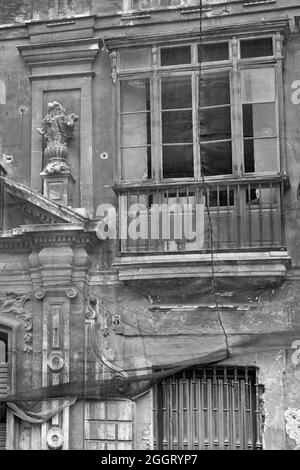 Schwarzweiß-Foto eines alten und schönen, aber heruntergekommenen Hauses in Sevilla, Spanien Stockfoto