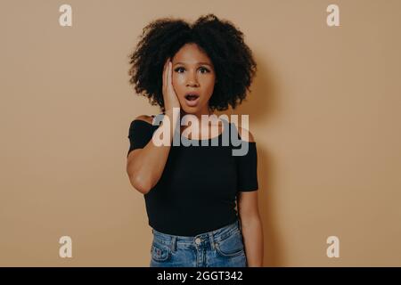 Studioportrait einer jungen, schockierten afrikanischen Frau mit unerwartetem Gesichtsausdruck Stockfoto