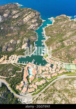 Blick von oben, atemberaubende Luftaufnahme des Dorfes Poltu Quatu mit seinem schönen Hafen voller Boote und Luxusyachten. Sardinien, Italien. Stockfoto