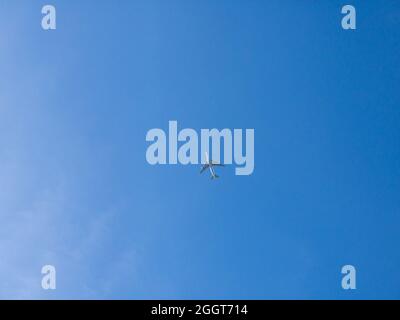 Blick auf den Flug tief mit blauem Himmel und Wolken im Hintergrund. Passagierflugzeuge über Kopf fliegen. Flugzeug in der Luft. Flugreise Stockfoto