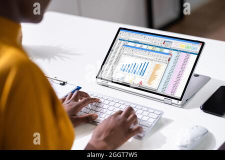 Frau, Die Mit Elektronischen Tabellenberichten Auf Dem Bildschirm Arbeitet Stockfoto