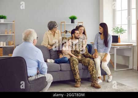 Glücklicher Soldat Mann spricht mit seiner Familie nach der Rückkehr aus dem Militärdienst. Stockfoto