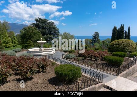Brunnen im Garten vor dem weißen Livadia-Palast in Jalta, Krim auf einem schönen Hintergrund mit dem Meer und Wolken Stockfoto