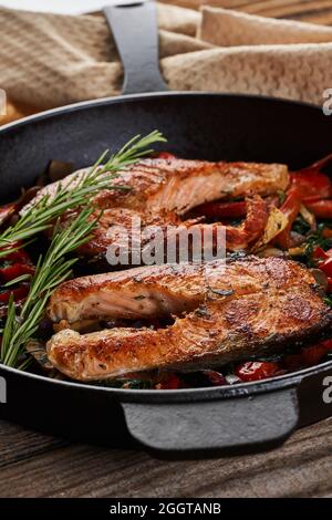 Gusseiserne Pfanne gekocht Alaska Wildlachs mit Kirschtomaten, Pfeffer, Pilze, Zwiebeln und Kräutern Stockfoto