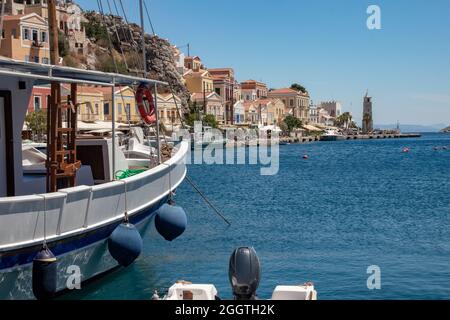 SYMI, Griechenland - 03. JUNI 2021. Der Hafen von Symi Stadt mit den Bezirken Chorio und Gialos ist einer der schönsten und romantischsten in der ganzen A Stockfoto