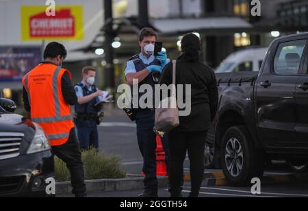 Auckland, Neuseeland. September 2021. Ein Polizeibeamter fragt einen Passanten in der Nähe des New Lynn Supermarkts in Auckland, Neuseeland, 3. September 2021. Der neuseeländische Premierminister Jacinda Ardern bestätigte, dass der gewalttätige Angriff, der am Freitag um 2:40 Uhr Ortszeit im Supermarkt von New Lynn in Auckland stattfand, ein „Terroranschlag“ war, der von einem „Extremisten“ ausgeführt wurde. Kredit: Zhao Gang/Xinhua/Alamy Live Nachrichten Stockfoto