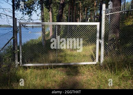 Geschlossenes Metalltor im Wald Stockfoto