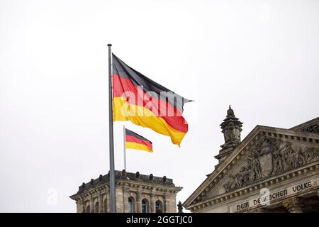 Berlin, Deutschland. September 2021. Auf dem Reichstagsgebäude, dem Sitz des Deutschen Bundestages, fliegen zwei deutsche Flaggen. Quelle: Carsten Koall/dpa/Alamy Live News Stockfoto