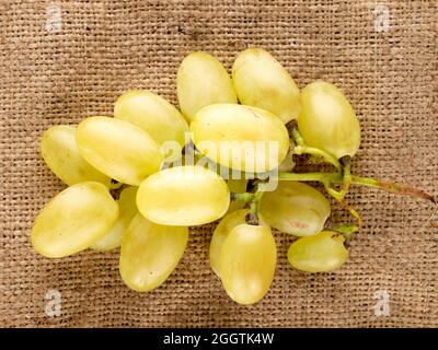 Ein Bund organischer saftiger grüner Trauben mit Jute-Beutel, Nahaufnahme, Draufsicht. Stockfoto