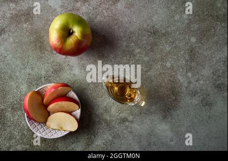 Apfelscheiben auf dem Teller, Apfelfrüchte und Saft auf rustikalem Holzhintergrund. Draufsicht. Speicherplatz kopieren Stockfoto