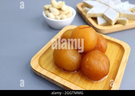 Diwali Diya, Süßigkeiten oder Mithai, und Blumen sind als festlicher Hintergrund angeordnet. Verschiedene Süßigkeiten Kaju Katli, Gulab Jamun und Churma laddu . Stockfoto