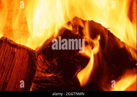 Das Gelb und Orange der Flammen, die durch Holz brennen Stockfoto