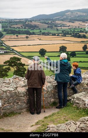 Besucher von Montgomery Castle bewundern die Aussicht von den Stadtmauern, Montgomery, Powys, Wales Stockfoto