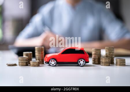 Spielzeugauto Vor Geschäftsmann, Der Darlehen Berechnet Stockfoto