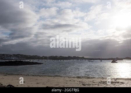 An einem launischen, windigen Sommerabend geht die Sonne über dem Hafen in Primel-Trégastel, Finistere, Bretagne, Frankreich unter Stockfoto