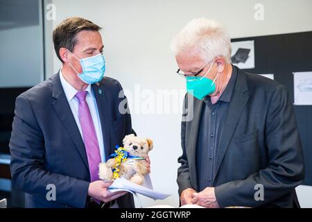 02. September 2021, Baden-Württemberg, Heidenheim: Dieter Henle, Oberbürgermeister der Stadt Giengen an der Brenz, überreicht während seines Besuchs bei der carbonauten GmbH ein Geschenk an den baden-württembergischen Ministerpräsidenten Winfried Kretschmann (Bündnis 90/die Grünen). Foto: Tom Weller/dpa Stockfoto