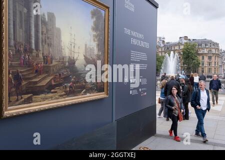 Die Öffentlichkeit bewundert eine Kopie von „Seaport with the Embarkation of Saint Ursula“ von Claude Lorrain (1641), die Teil einer temporären Ausstellung historischer Kunst ist, die vor der National Gallery platziert wurde, um Passanten zu zeigen, was in ihren Galerien am 1. September 2021 auf dem Trafalgar Square, London, zu sehen ist. England. Stockfoto