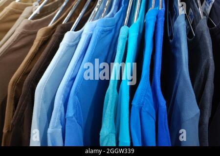 Rainbow farbige Kleider auf Kleiderbügeln im Ladengeschäft. Mode und Shopping Konzept Stockfoto