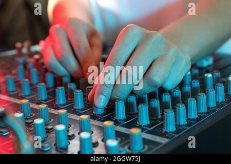 Der Musiker passt den Ton auf dem Audio-Mixer an Stockfoto