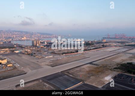 Haifa Flughafen und Start- und Landebahn mit der Skyline der Stadt im Hintergrund, Luftaufnahme. Stockfoto