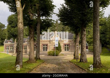 SOEST, NIEDERLANDE - 21. Aug 2021: Eingangsstraße durch Baumreihe, die zum Bau des niederländischen Frischwasserversorgungsunternehmens Vitens im Grünen führt Stockfoto