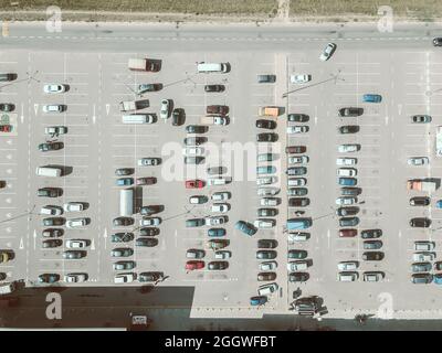 Drohnenansicht eines großen Parkplatzes an einem sonnigen Sommertag, horizontaler Parkplatz. Tönung von Fotos im sommerlichen Kinostil Stockfoto