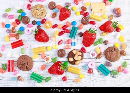 Obst, Kekse und Süßigkeiten auf weißem Holztisch. Party-Dessert Stockfoto