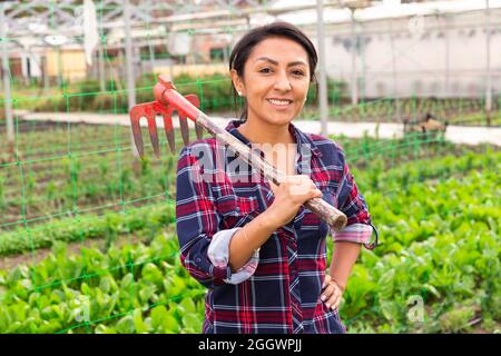 Gärtnerin, die mit Rechen steht Stockfoto
