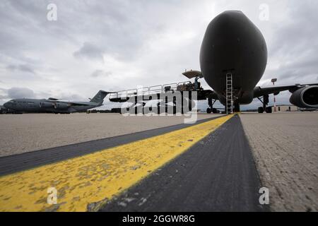 Mitarbeiter der Luftwaffe der Republik Singapur und ein US-Luftwaffenflieger des 726. Air Mobility Squadron laden Fracht auf einen RSAF A330 Multi-Role-Tanker Transportflugzeug auf dem Luftwaffenstützpunkt Spangdahlem, Deutschland, 29. August 2021. Eine Kontingenz von Mitgliedern der Streitkräfte Singapurs, bestehend aus Luftbesatzung, Ingenieuren und Sicherheitskräften, traf in Spangdahlem ab ein, um mehrere Transportwiederholungen für bis zu 200 Evakuierte aus Afghanistan gleichzeitig zu fliegen. (USA Air Force Foto von Tech. Sgt. Maeson L. Elleman) Stockfoto