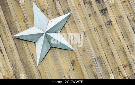 Hellblauer Stern auf einem Hintergrund von diagonalen rustikalen gelben Kiefernbeadboard. Speicherplatz kopieren. Stockfoto