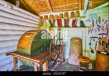 PEREIASLAV, UKRAINE - 22. MAI 2021: Die mittelalterliche Gerberei-Werkstatt mit Ledergerbtrommel, Gerberwerkzeugen und Beispielen der handgefertigten Vintage-Stiefel Stockfoto