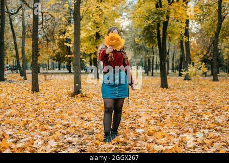 Gesichtsloses Porträt einer Frau mit Ahornblättern. Aktivitäten für Happy Fall, verbessern Sie sich, Möglichkeiten, glücklich und gesund Herbst. Umarmen Sie Das Leben, Mindfuln Stockfoto