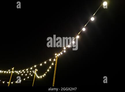 Eine viele Glühbirne mit Kabel in der Nacht Stockfoto