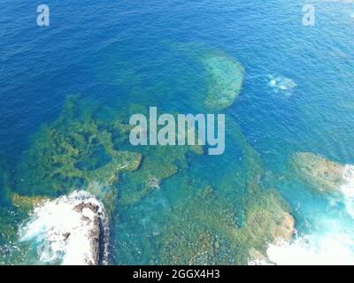 Drohnenansicht des tiefblauen Atlantischen Ozeans mit einer wunderschönen und bizarren Unterwasser-Felsformationen Stockfoto