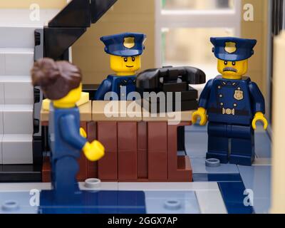 Tambow, Russische Föderation - 02. August 2021 drei Lego-Polizisten in der Nähe eines alten Telefons in einer Polizeistation. Stockfoto