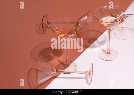 Roséwein in Cocktail-Roségläsern auf weißem und rosafarbenem Hintergrund Stockfoto